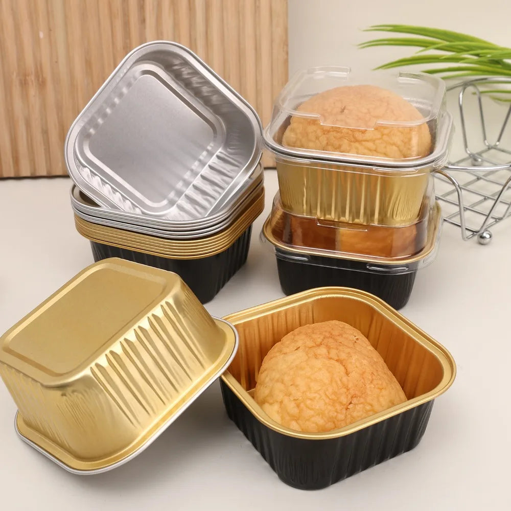 A set of square aluminum foil baking boxes with transparent lids stacked and displayed on a white surface.