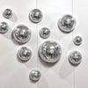 A collection of silver disco balls mounted on a white surface.