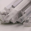A close-up view of a pack of clear disposable drinking straws lying on a white surface.