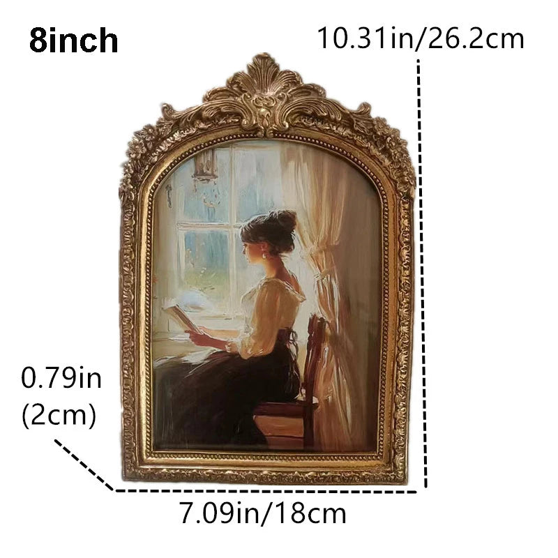 An oval vintage resin photo frame with a gold-colored ornate frame and a painting inside.