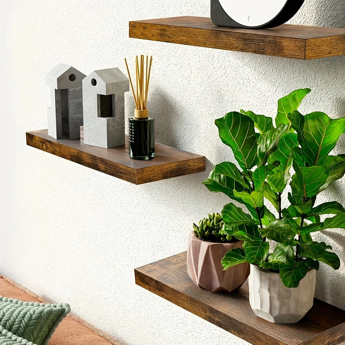 Wooden floating wall shelves displaying decorative items like birdhouses and a potted plant.