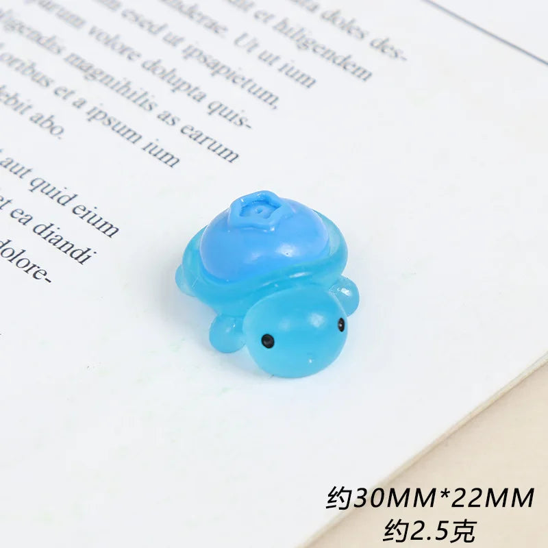 A small, translucent blue resin charm shaped like a fruit turtle for DIY crafts.