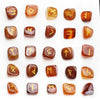 Una colección de 25 piedras runas de cristal natural en varios tonos de ámbar y marrón.
