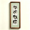 A vertical photo strip frame with a walnut wood border and a green gingham background, displaying six portrait photos of a co