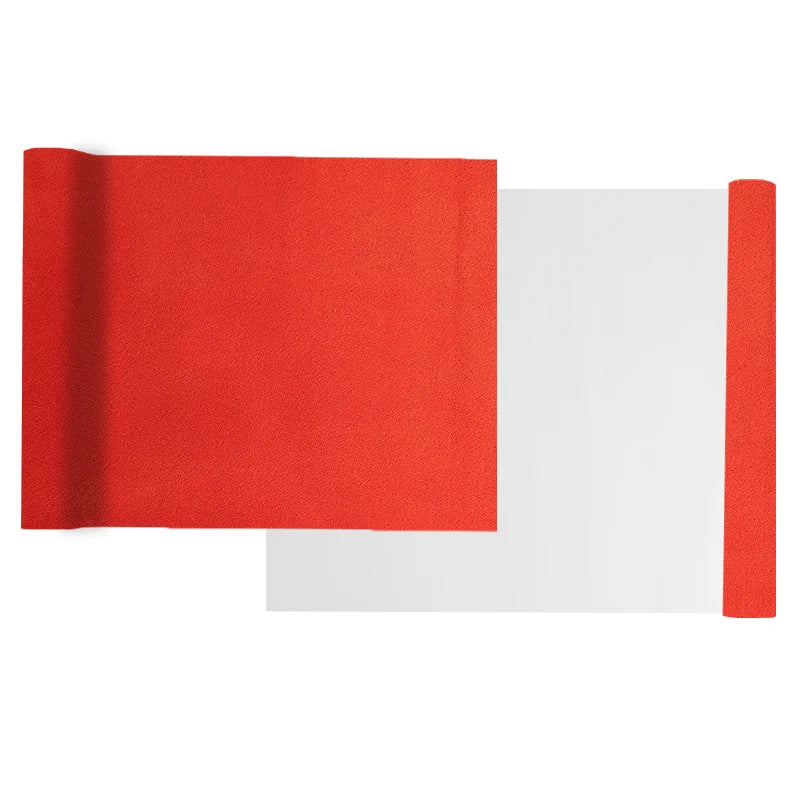 A roll of red suede wrap fabric next to a sheet of white fabric for DIY projects.