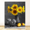 Black and white photo of sunflowers in a vase with pears on a wooden surface