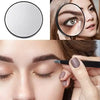 A close-up of a magnifying compact mirror with a suction cup and a woman using it to examine her eye.