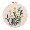Punch needle embroidery kit featuring a daisy sunflower design on a piece of cloth with tools.