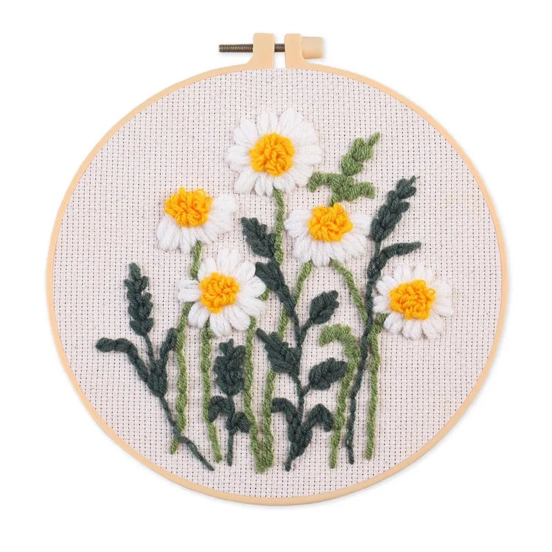 Punch needle embroidery kit featuring a daisy sunflower design on a piece of cloth with tools.