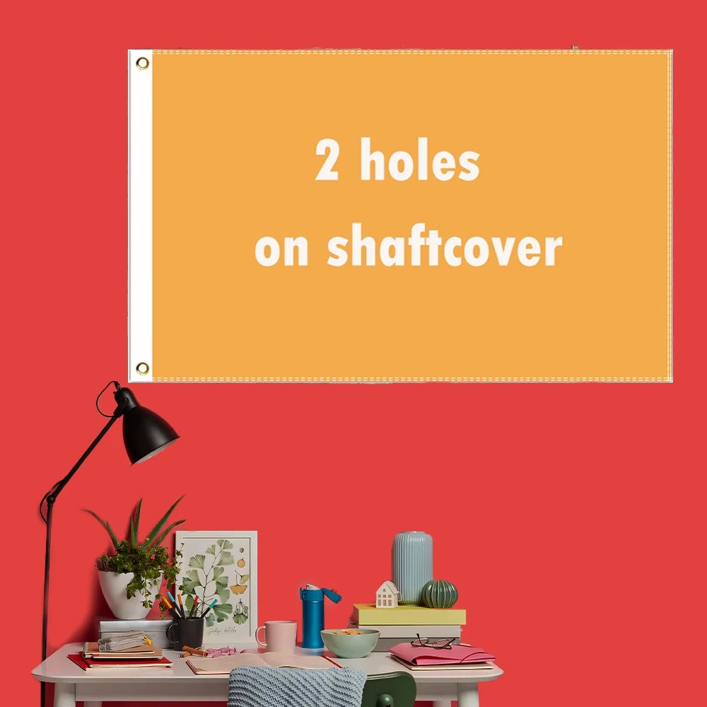 A bright orange rectangular sign with the text Two holes on shaftcover displayed on a red wall.