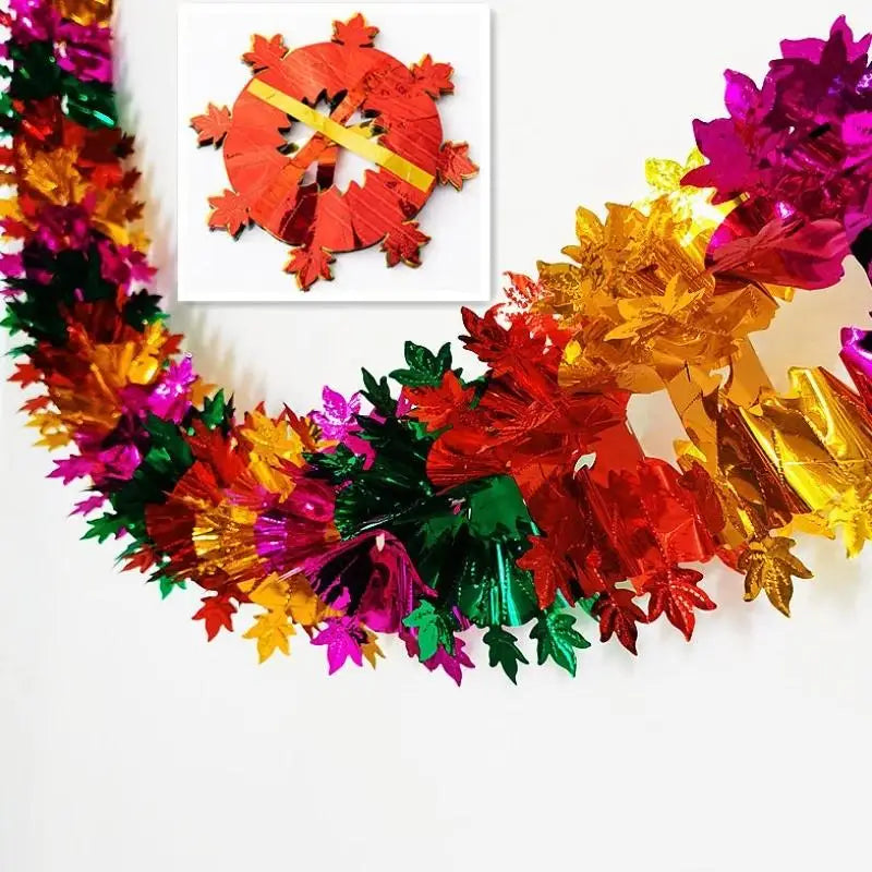 A shimmering tinsel garland ribbon featuring red, orange, yellow, and green leaves for holiday decor.