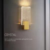 Modern bubble crystal LED wall sconces with a gold accent mounted on a gray wall.