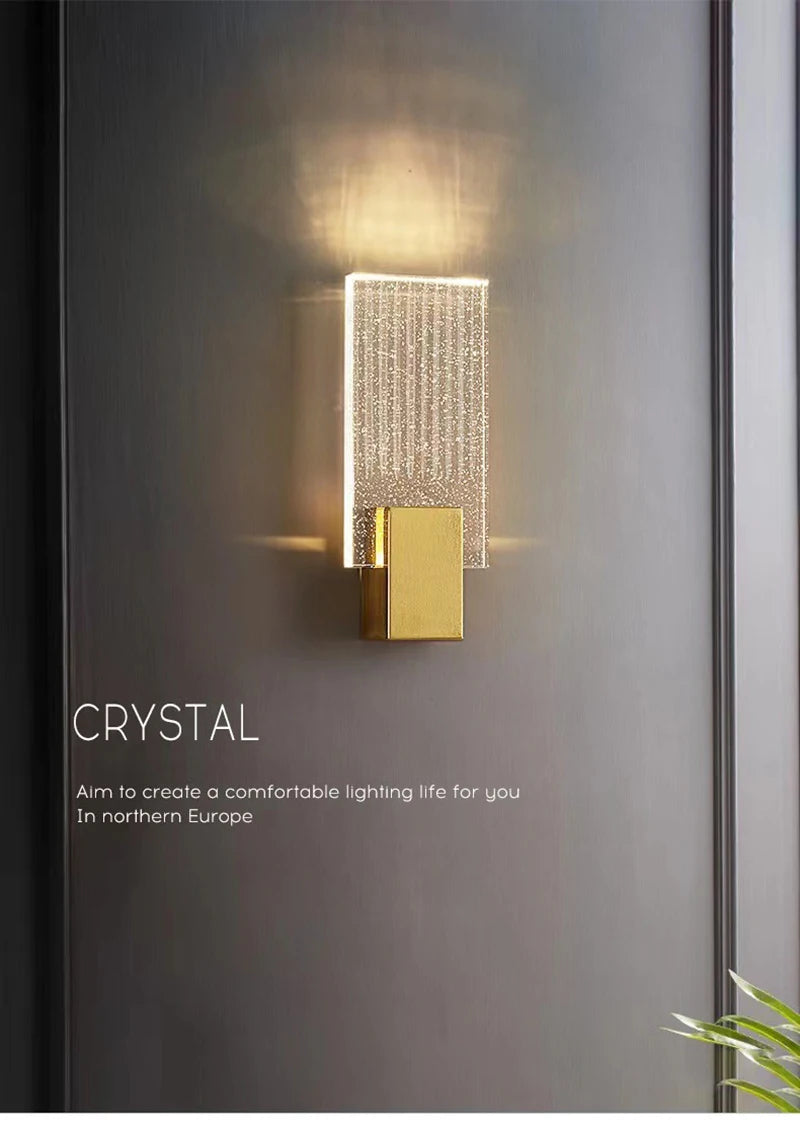 Modern bubble crystal LED wall sconces with a gold accent mounted on a gray wall.