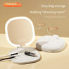 A white LED makeup mirror with a round frame is shown in its developed and folded states on a light surface.