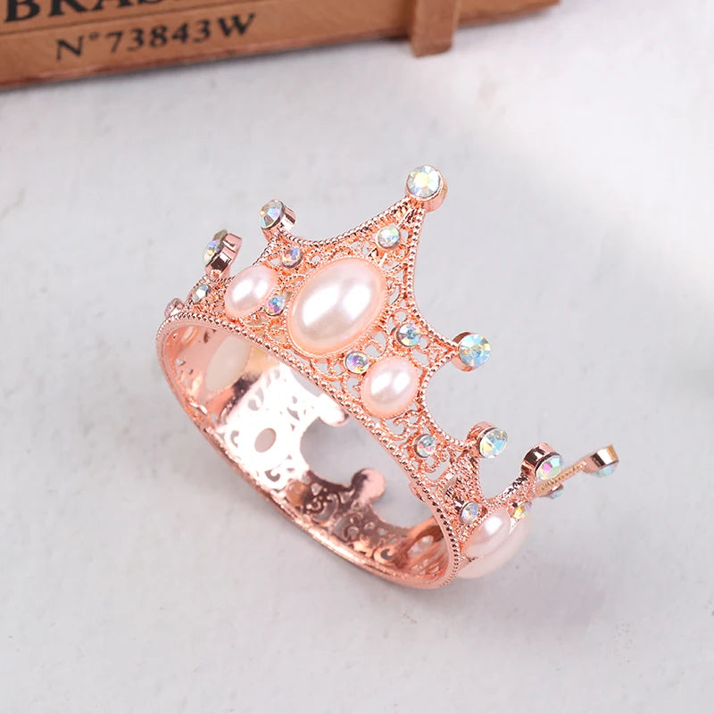 A delicate rose gold pearl tiara crown cake topper and hair accessory with sparkling accents.