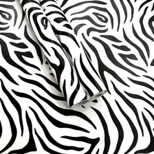 Rolls of zebra print self-adhesive peel and stick wallpaper on a white background.