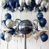A collection of navy blue and gold metallic balloons with pearl finishes hanging in a vertical display.
