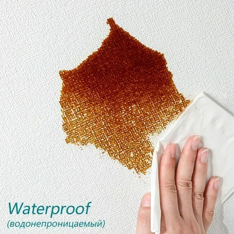 A hand is peeling off a piece of waterproof, textured brown wallpaper panel from a white surface.