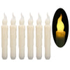 A set of six white taper candles with fluted tops, shown next to a lit candle in a black oval.