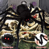 Giant plush black spider with scary red eyes and spindly legs lying on a bone structure.