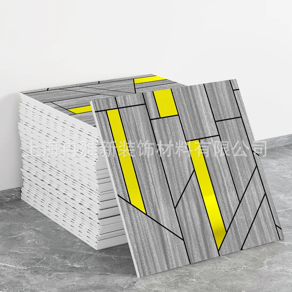 A stack of gray and white marble peel-and-stick tiles with yellow accents displayed on a gray floor.