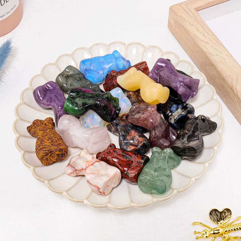 Colección de figuras de piedras curativas de cuarzo rosa natural en varios colores y formas, exhibidas en un plato blanco.