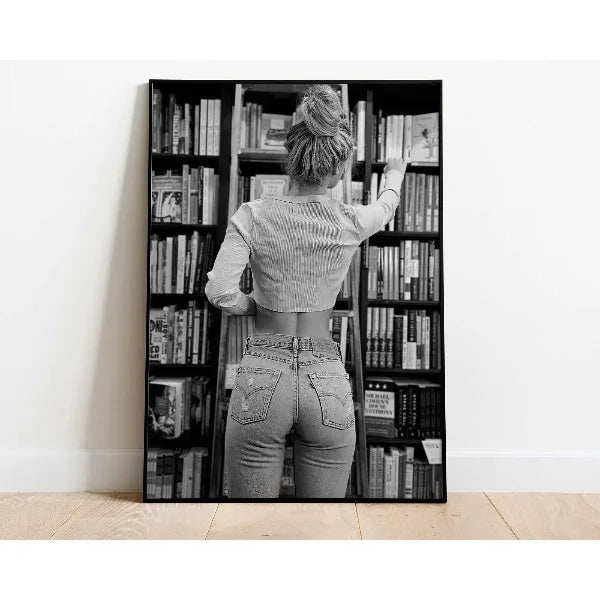 A woman with her back to the camera is looking into a tall bookshelf filled with books.