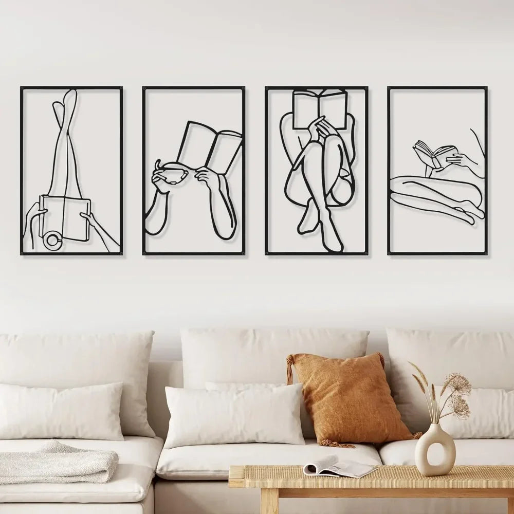 A set of four black line art prints depicting female figures reading books displayed on a white wall above a light-colored so