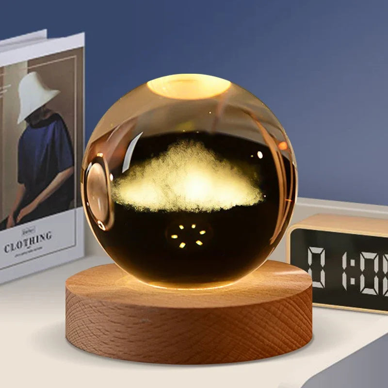 A dark glass crystal ball with a glowing interior sits on a wooden base.