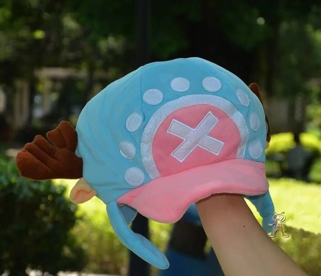 A light blue knit cap plush toy featuring a pink brim and white pom-pom details.