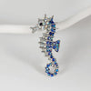 Vintage marine life brooch pin set featuring a silver-toned dragon head and scales adorned with blue and clear rhinestones