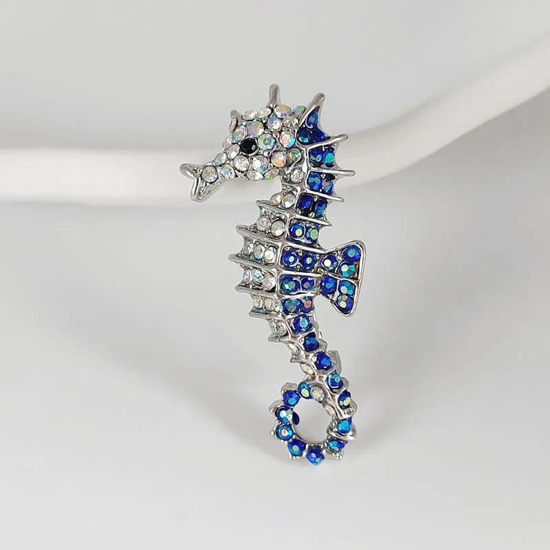 Vintage marine life brooch pin set featuring a silver-toned dragon head and scales adorned with blue and clear rhinestones