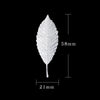 A single, detailed tea brewing leaf in sterling silver, shown against a black background.