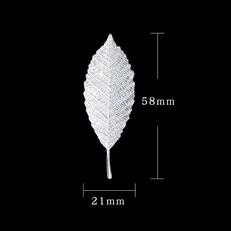 A single, detailed tea brewing leaf in sterling silver, shown against a black background.