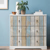 A white cabinet with wooden plank style doors featuring vintage blue and white distressed wallpaper.