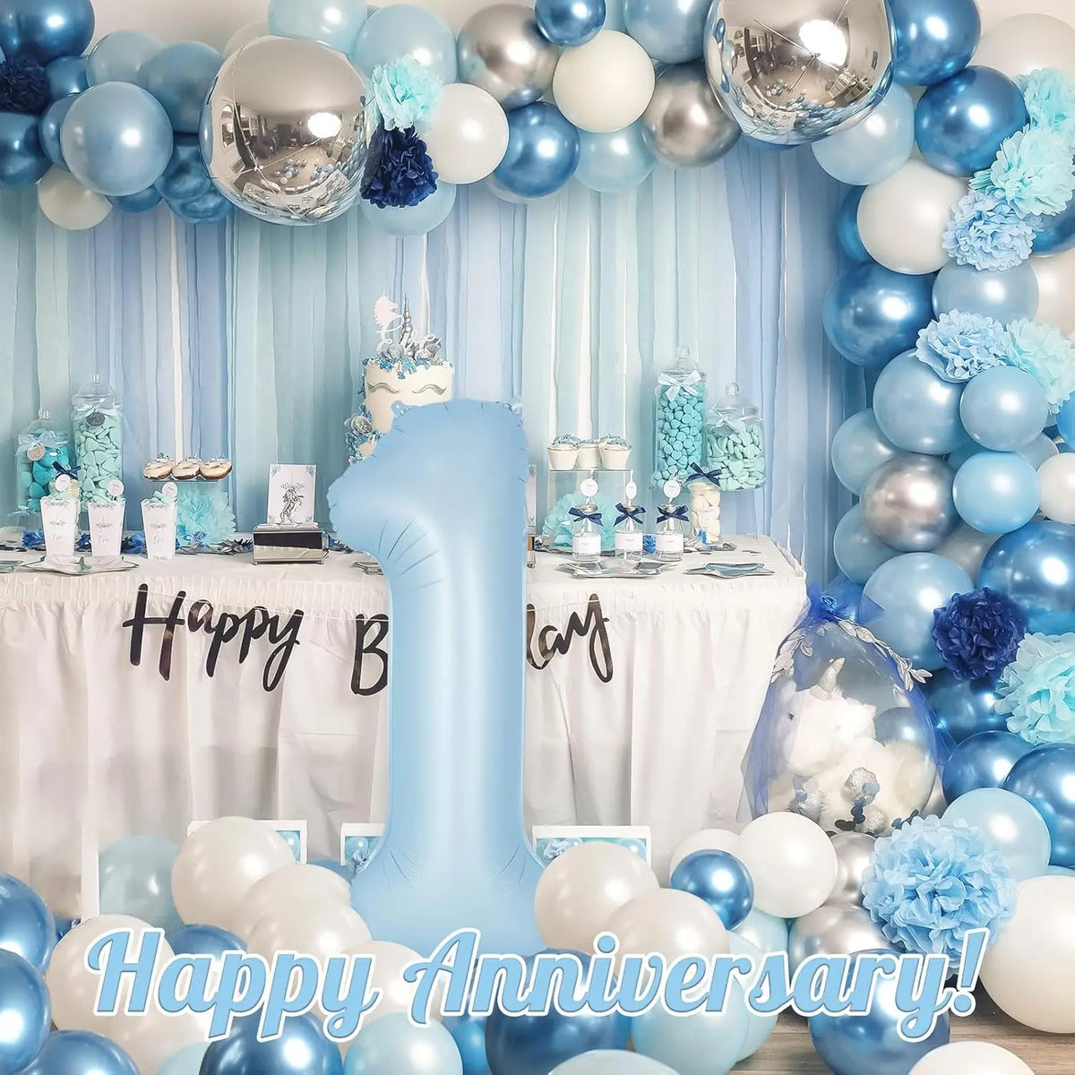 A large light blue foil number balloon shaped like the number one is surrounded by blue and silver balloons for a birthday ce