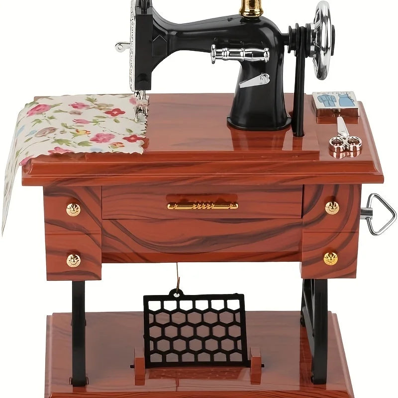 A vintage clockwork music box featuring a black sewing machine on a wooden table.