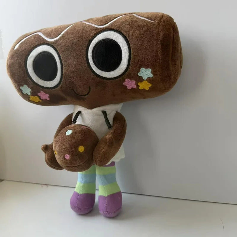 A brown plush toy resembling a character with large black eyes and small floral details, wearing a white top and striped pant