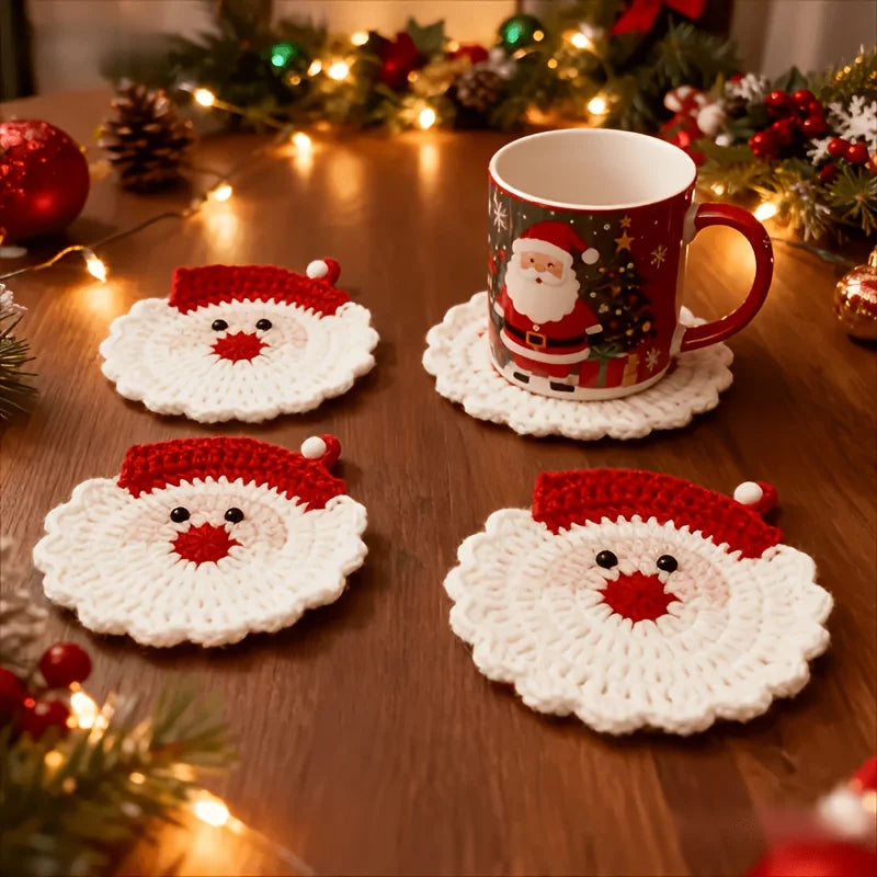 A set of handmade crochet Santa Claus coasters featuring a white beard and red hat, displayed on a wooden table.