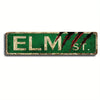 A vintage metal wall sign with the text ELM St. in distressed white lettering on a dark green background, featuring stylized 