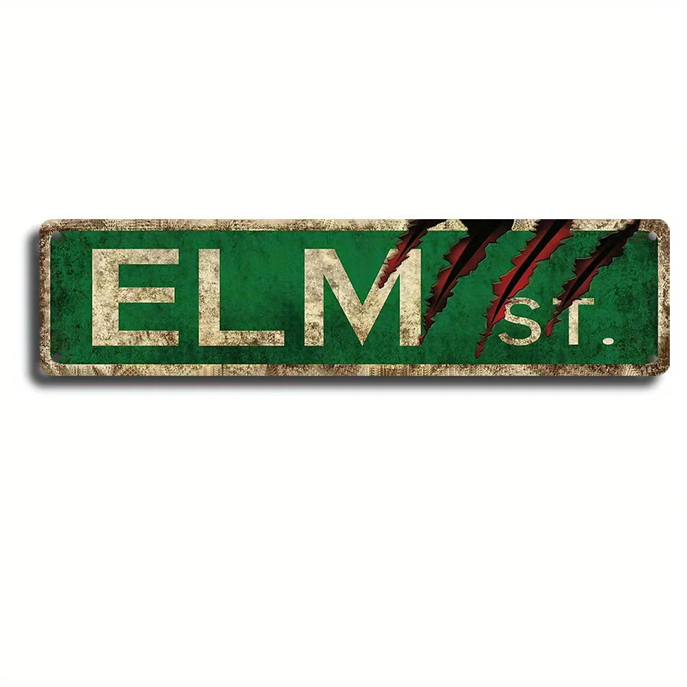 A vintage metal wall sign with the text ELM St. in distressed white lettering on a dark green background, featuring stylized 