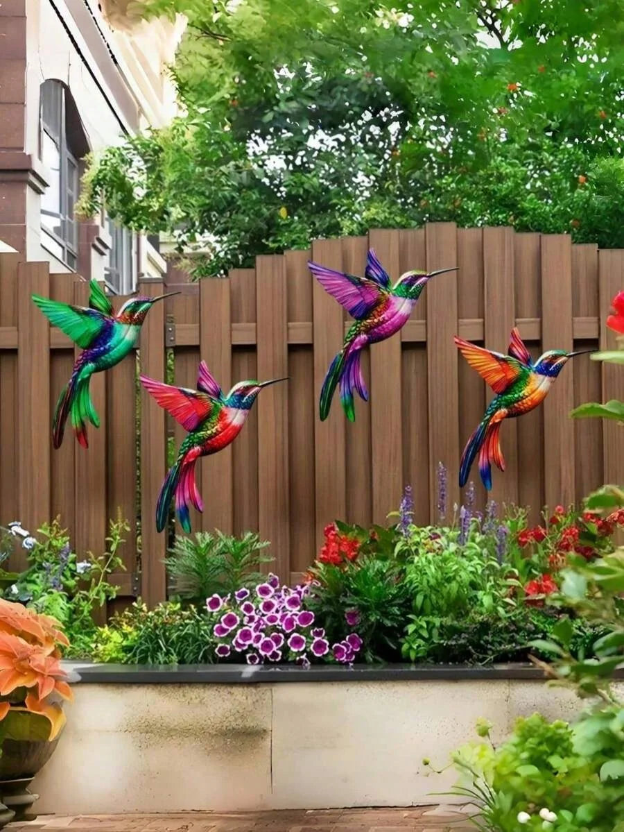 Set of four metal hummingbird wall decor featuring vibrant iridescent colors against a wooden fence backdrop.