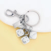 A silver keychain featuring a golden dice charm and a rectangular tag.
