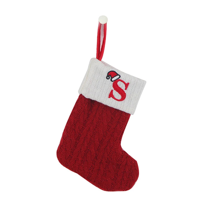 Red knitted sock ornament with a white cuff featuring a red letter S and a hanging loop.