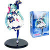 A PVC collectible figurine of Hatsune Miku in a white and blue outfit with accessories, displayed next to its packaging box.
