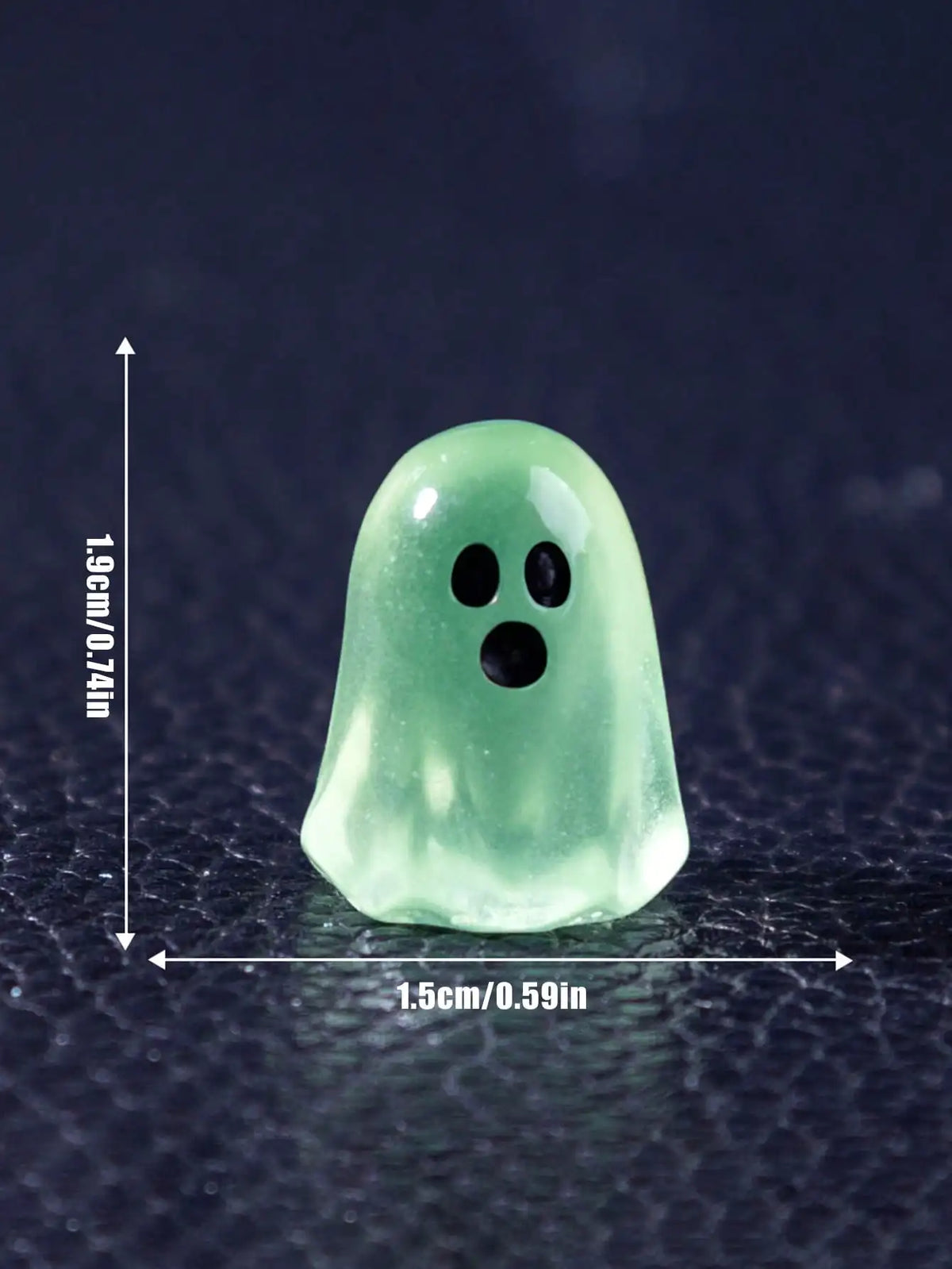 A translucent green ghost figurine with two black eyes, shown against a dark background.