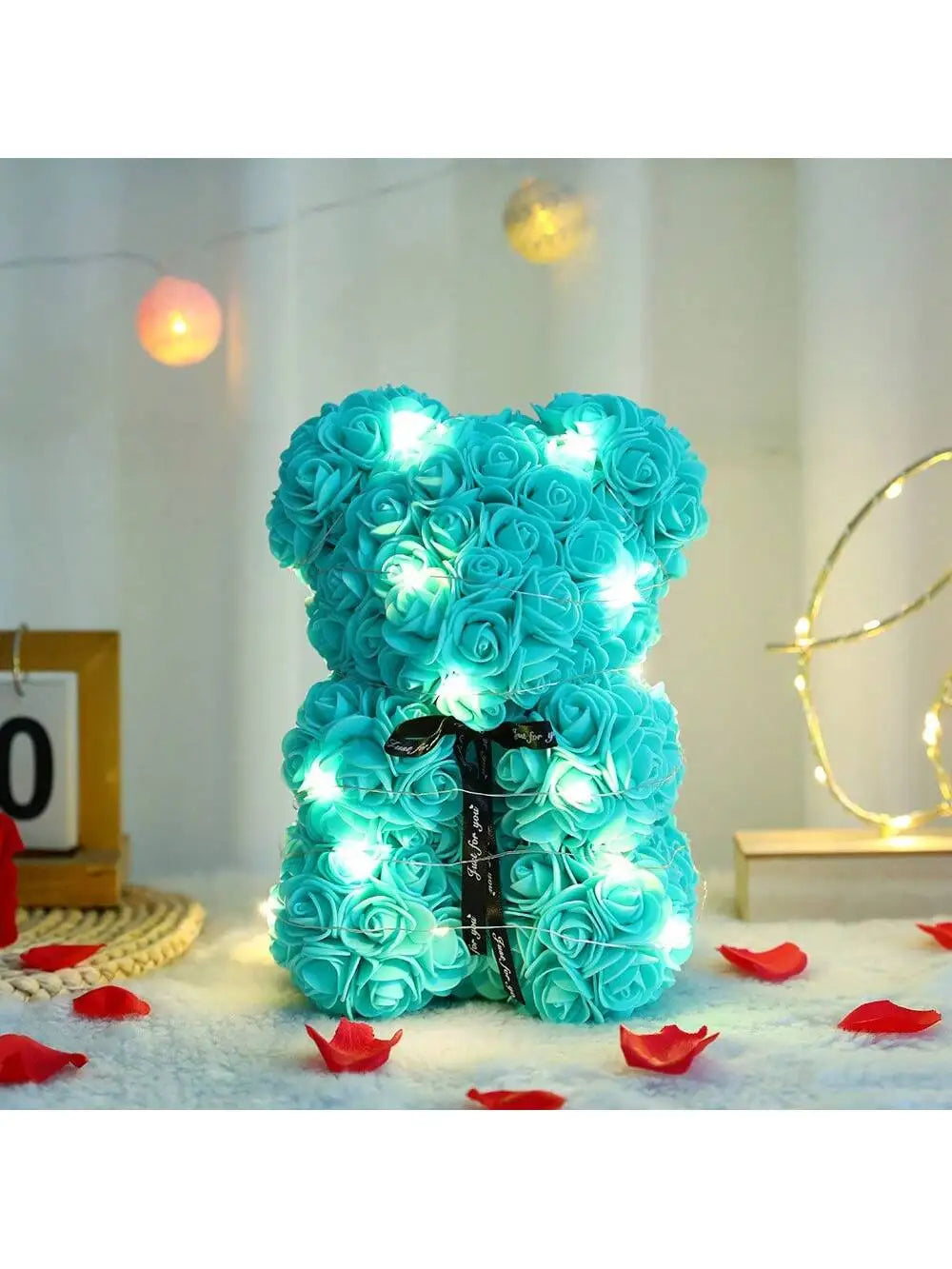 Heller blauer künstlicher Rosen-Teddybär mit leuchtenden LED-Lichtern auf weißem Untergrund.