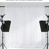 A white sheer fabric drape is shown hanging in a studio setting, used as an elegant backdrop.