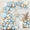 A floral arch made of light blue and gold latex balloons decorated with dried pampas grass and white accents.