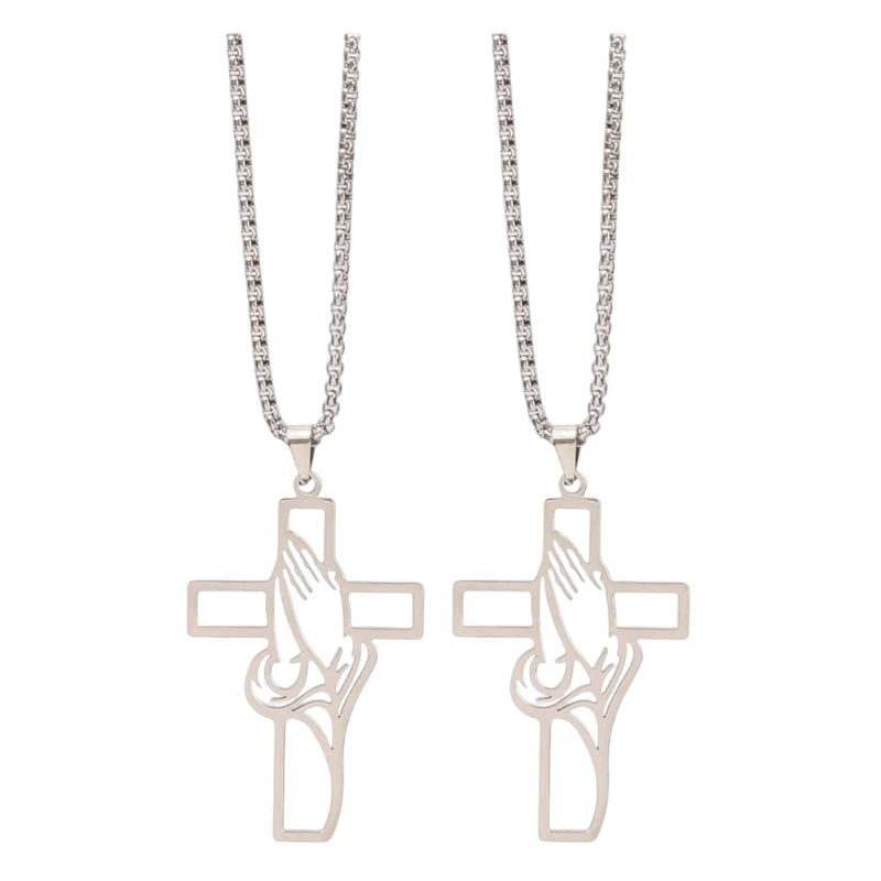 A pair of stainless steel praying hands cross pendants hanging from chains.
